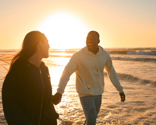 istock Casually Dressed Loving Young Couple Running Along Beach Shoreline Through Waves At Sunrise 2096278182