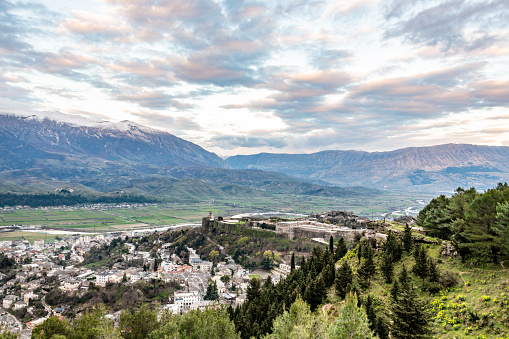View over trees to the town of Gjirokaster and far mountains