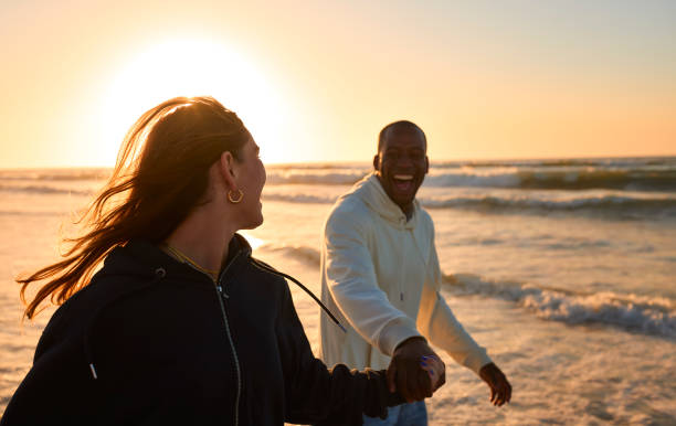 istock Casually Dressed Loving Young Couple Running Along Beach Shoreline Through Waves At Sunrise 2096285364