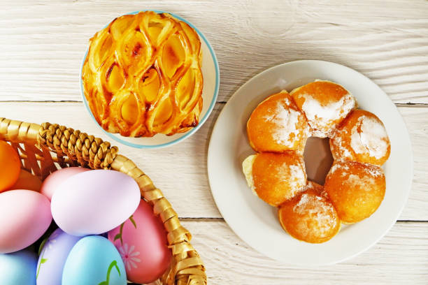 Easter Eggs in Wicker Basket and Apple Pie table top view copy space stock photo