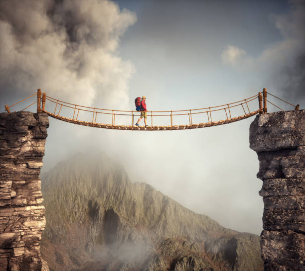 istock Hiker walking on a suspension bridge between mountains. 2096298009