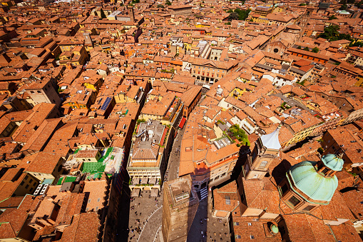 Bologna, Italy, 05.18.2018 - cityscape from Asinelli tower, Two Towers, Due Torri. Buildings, tiled roofs and streets of Bologna. Italian red city.