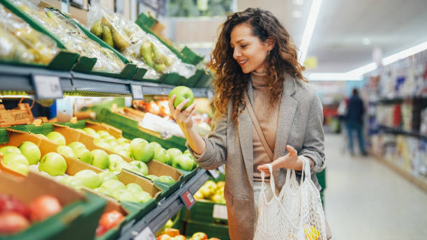 millennial generation woman shopping at grocery store with reusable bag - mua hàng tại siêu thị hình ảnh sẵn có, bức ảnh & hình ảnh trả phí bản quyền một lần