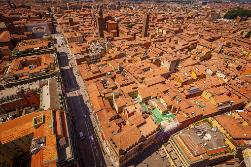 Bologna, Italy, 05.18.2018 - roofscape from Asinelli tower, Two Towers, Due Torri. Buildings, tiled roofs and streets of Bologna. Italian red city.