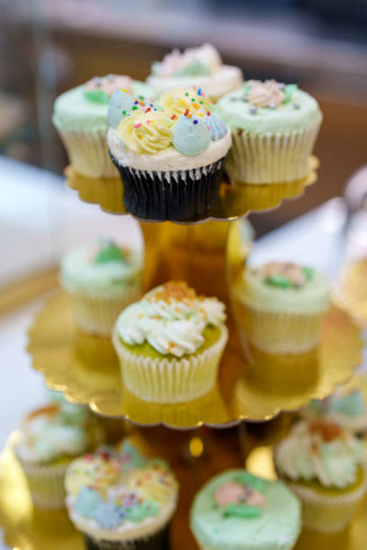 Various cupcakes are arranged on a tiered cupcake stand