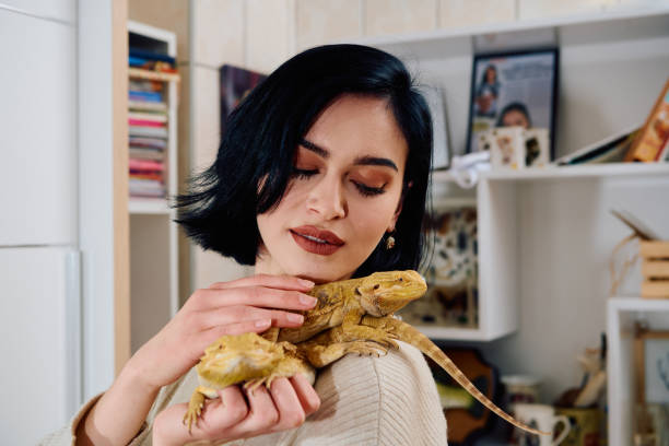 istock Beautiful Woman Posing with Her Two Adorable Bearded Dragon Pets 2096402833