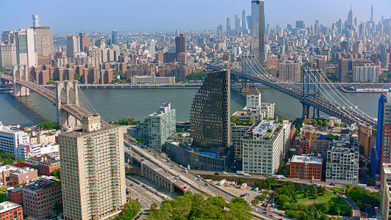 Aerial view of Manhattan Bridge and Brooklyn Bridge over East River surrounded by skyscraper buildings, New York City, New York State, USA.