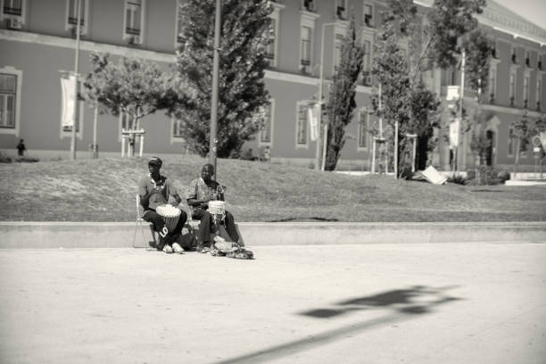 Lisbon, Portugal - July 29, 2023: A couple of street musicians play percussion on a street in Lisbon downtown.