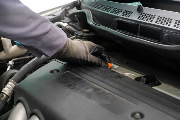 istock Mechanic man hand checking engine oil refill car maintenance close up 2096407080