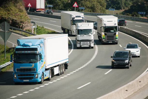 trucks overtaking on a highway - infraestructuas fotografías e imágenes de stock