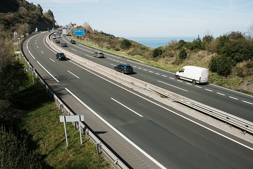 A multiple lane highway as seen from a bridge crossing it