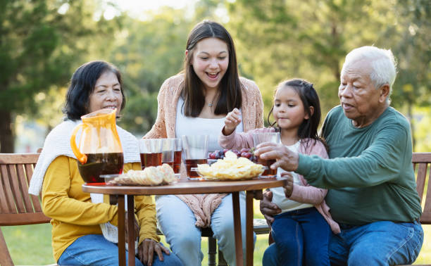 asian grandparents with two granddaughters eating outdoors - filipino ethnicity grandfather senior adult family - fotografias e filmes do acervo