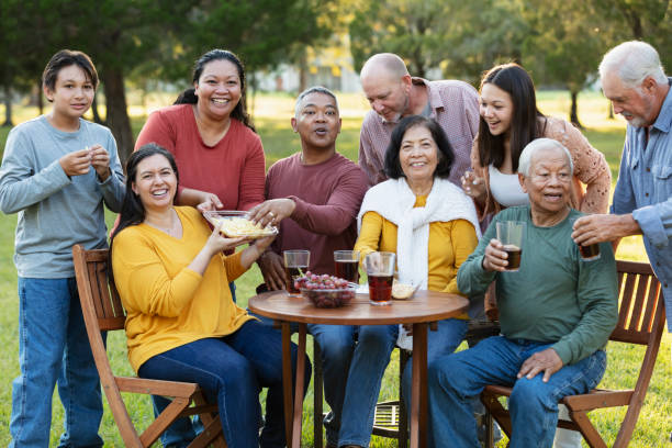 família extensa multirracial fazendo piquenique no quintal - filipino ethnicity grandfather senior adult family - fotografias e filmes do acervo