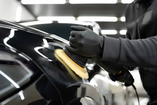 Professional detailing a car in car studio, hands with orbital polisher, scratching remover, vehicle care concept.