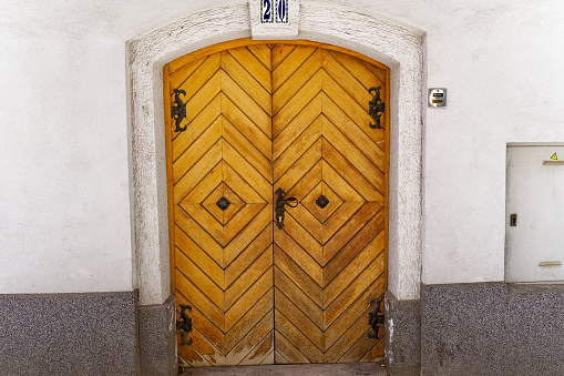 Idyllic view of the old town of Slovenian City of Kranj with close-up of wooden door of house number 20 on sunny summer day. Photo taken August 11th, 2023, Kranj, Slovenia.