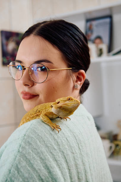 istock Beautiful Woman Posing with Her Adorable Bearded Dragon Pets 2096436111