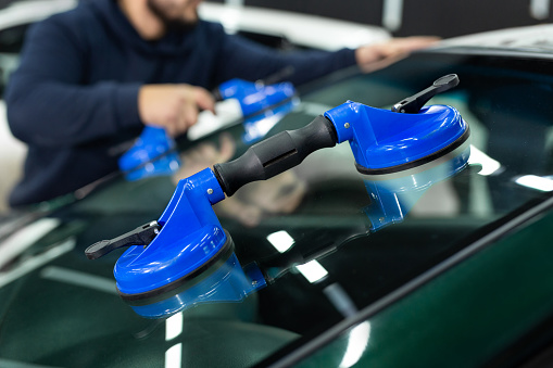 Glass of the car is a close-up in the room, removed with the help of professional suction cups. The process of car repair
