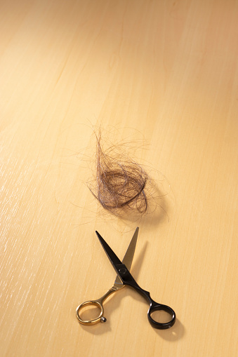 Scissors and hair laying on the floor together