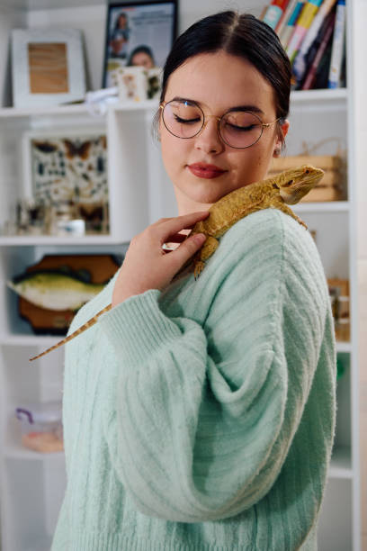 istock Beautiful Woman Posing with Her Adorable Bearded Dragon Pets 2096457169