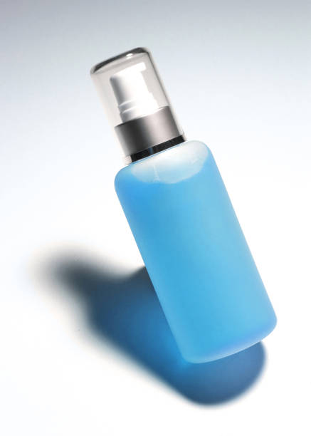Spain. Open perfume bottle on the table in the foreground. In the background, a man blurred as he buttons his shirt.