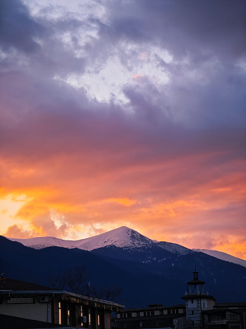Sunset casting warm light on mountain and rooftops