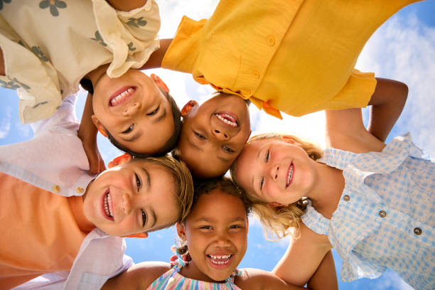 istock Group Of Multi-Cultural Children Friends Linking Arms Looking Down Into Camera 2096478324