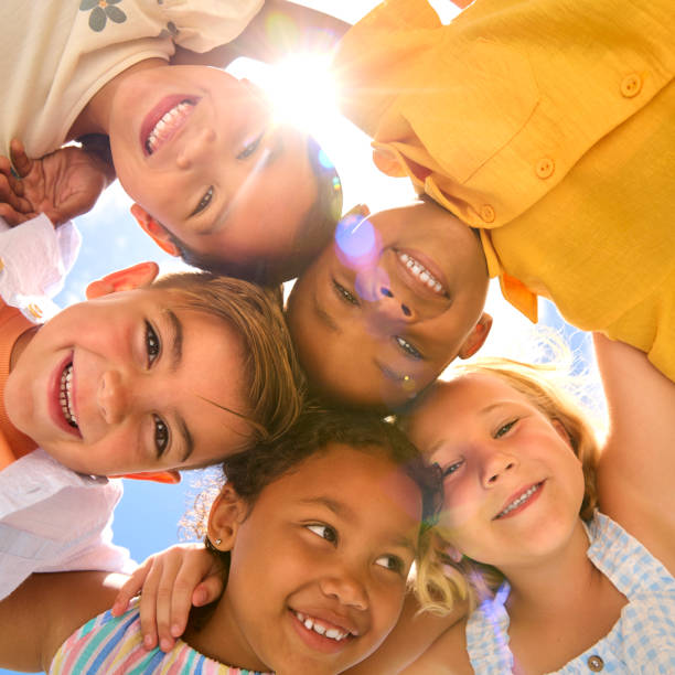 istock Group Of Multi-Cultural Children Friends Linking Arms Looking Down Into Camera 2096480419