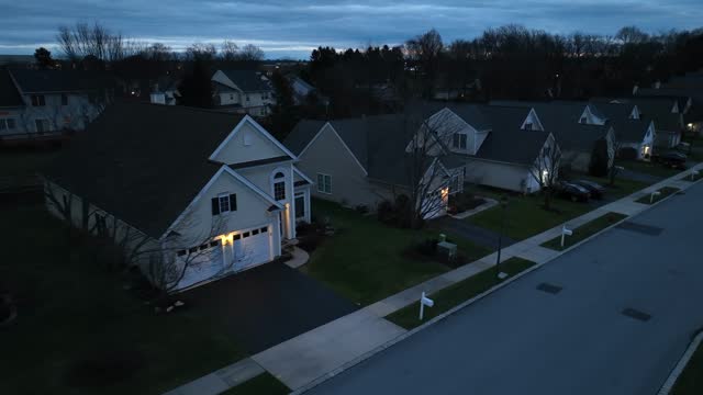 Residential American street at night. Aerial shot of standalone houses in 55+ retirement community in USA during winter dusk.