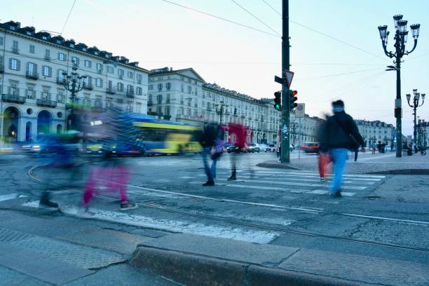 People crossing main street in Turin square at blue hour