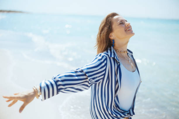 istock smiling modern female on beach rejoicing 2096521224