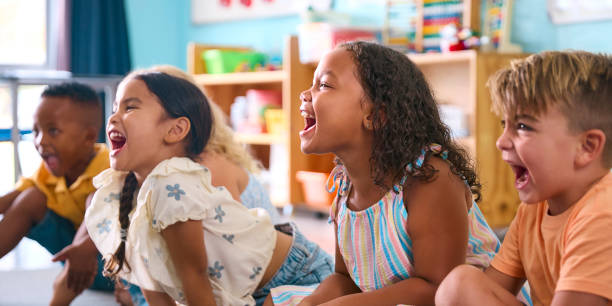istock Line Of Smiling Primary Or Elementary School Students Sitting On Floor During Classroom Lesson 2096528059