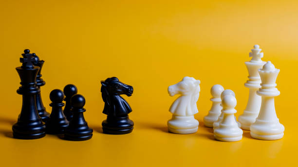 istock Two chess pieces, one black and one white, are on a yellow background 2096531505