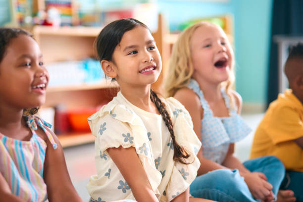 istock Line Of Smiling Primary Or Elementary School Students Sitting On Floor During Classroom Lesson 2096532623