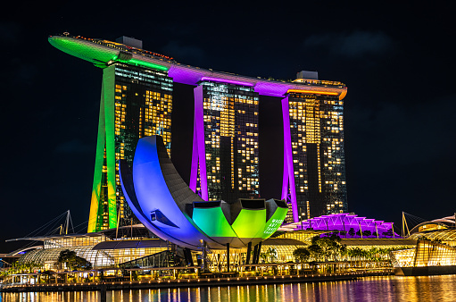 Singapore, 19 March 2024: Marina Bay Sands hotel in Singapore of light at night, its bright illumination reflected in waters. ArtScience Museum and Helix Bridge join luminous cityscape