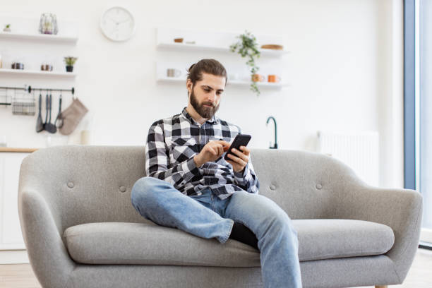istock Caucasian male holding smartphone while staying in modern workplace at home. 2096534811