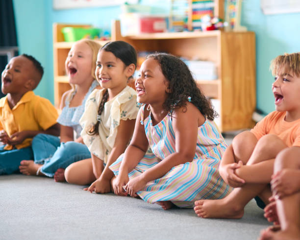 istock Line Of Smiling Primary Or Elementary School Students Sitting On Floor During Classroom Lesson 2096539056