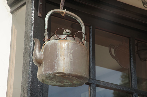 A weathered object hanging from the eaves of a coffee shop, photographed from the public road side, photographic data, March 2024, Kanagawa Prefecture, Kamakura City, Japan