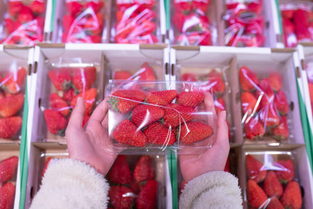 istock Child's hand holding strawberries in a pack 2096553310