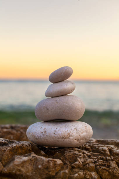 istock Pile of Stones on Tranquil Beach at Sunset 2096560574