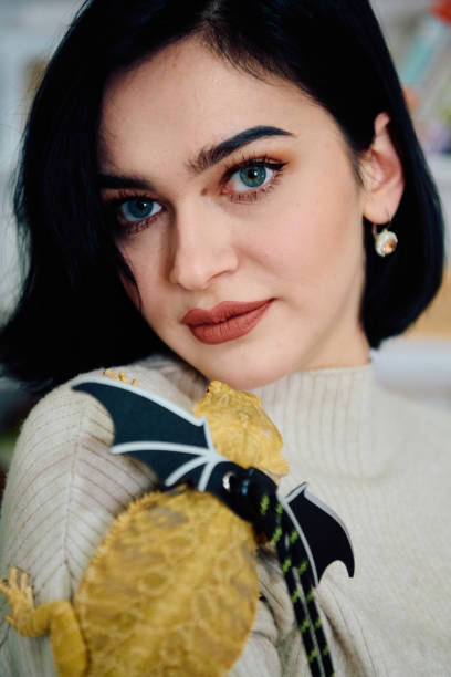 istock Beautiful Woman Posing with Her Adorable Bearded Dragon Pets 2096566076
