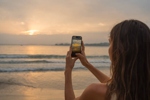 istock Young woman takes photo on beach 2096573985