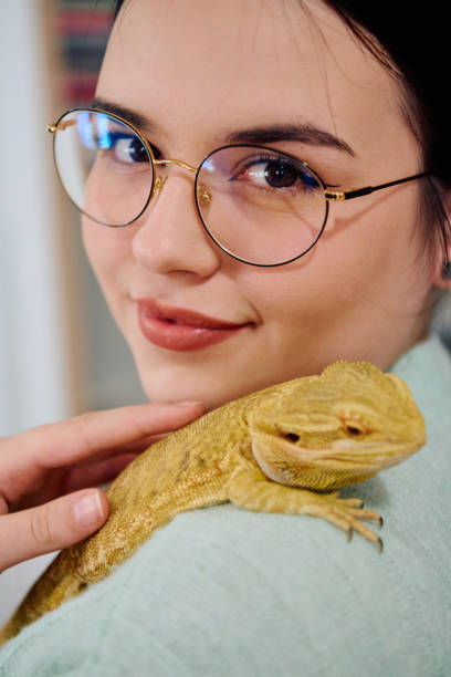 istock Beautiful Woman Posing with Her Adorable Bearded Dragon Pets 2096580923