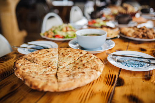Khachapuri with beans on old wooden table