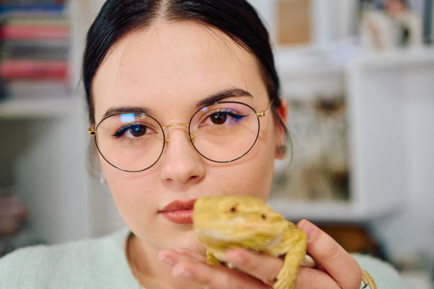 istock Beautiful Woman Posing with Her Adorable Bearded Dragon Pets 2096587247