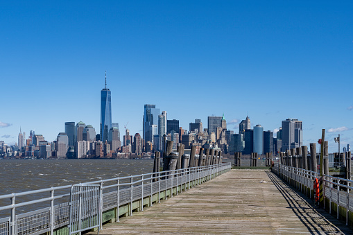 Skyscrapers on Manhattan, New York, USA with a jetty on Liberty island in the foreground.