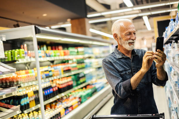 istock Customer scanning a product at wholesale while using his smartphone. The male customer takes a picture of the product and sends it to someone. 2096593660
