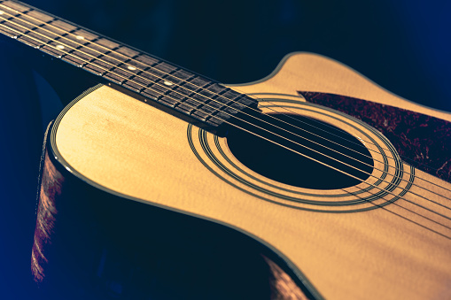 Musical background with acoustic guitar. Close up of guitar and strings with shallow depth of field, soft focus.
