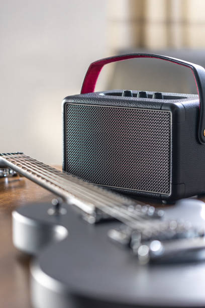 istock Black electric guitar and speaker on a wooden table. 2096607942