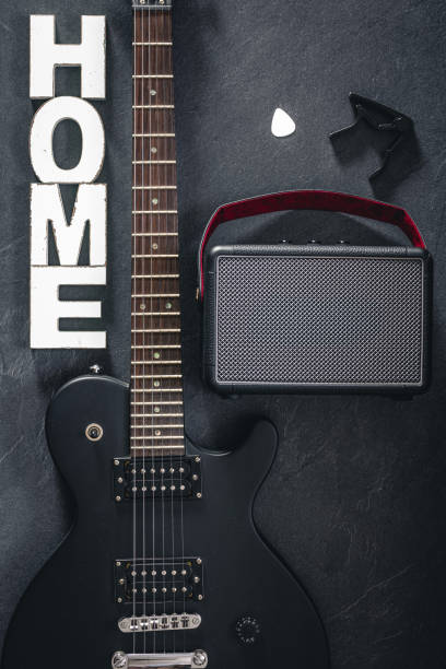 istock Electric guitar and amplifier on a dark background with decorative word Home. 2096607951