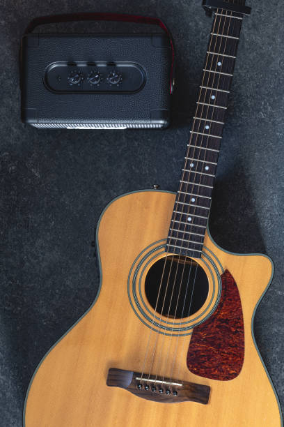 istock Acoustic guitar and speaker on black background, top view. 2096607953